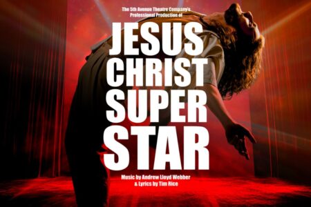 A dramatic stage performance with a person leaning back under a spotlight, arms extended, with bold white text reading 