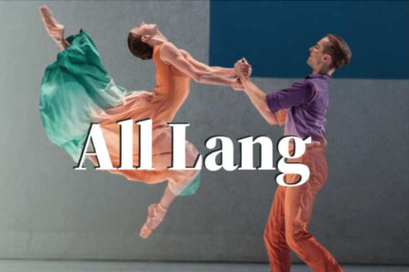 A male and female dancer perform a lift; the woman, in a flowing green and orange dress, is airborne, while the man, in a purple shirt and orange pants, supports her. Text 