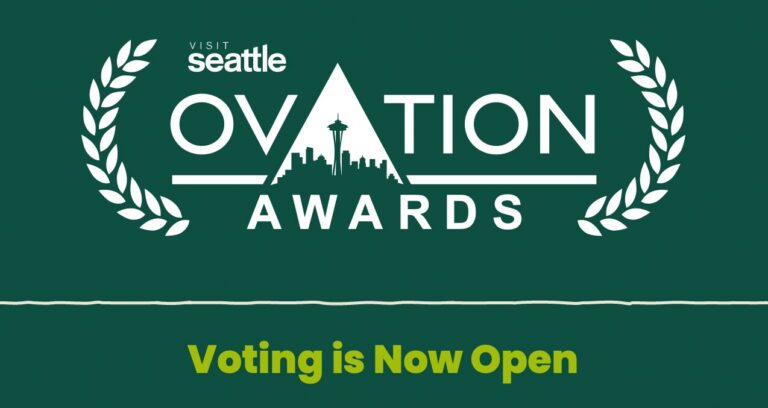 Logo reading "Visit Seattle Ovation Awards" with a city skyline in the letter A, white laurel branches, and the text "Voting is Now Open" in yellow on a dark green background.