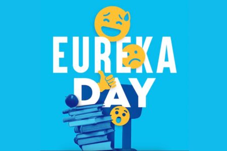 The text “EUREKA DAY” in bold white letters, with a stack of blue books and three expressive emojis showing laughing, frowning, and shocked faces.