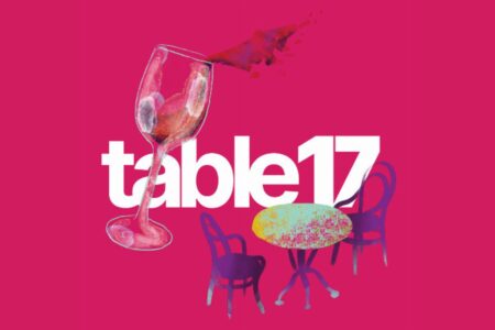 The text “table17” displayed over a pink background with an illustration of a wine glass, a small table, and two chairs.